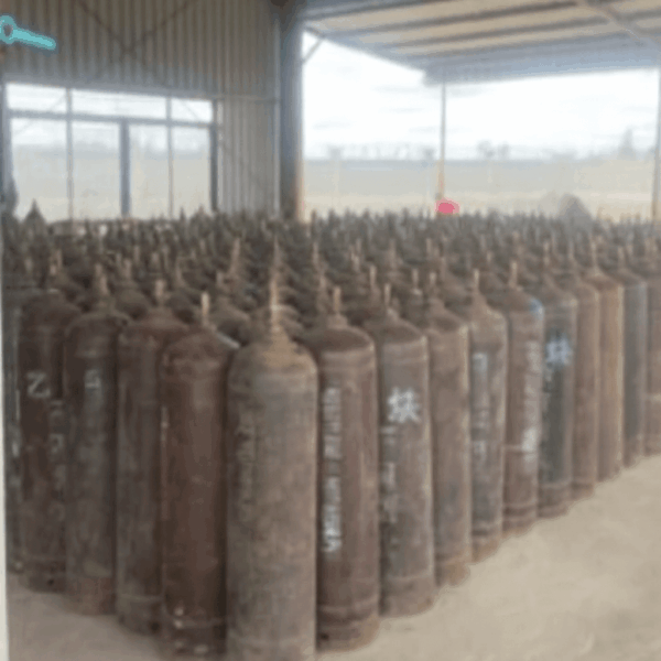 Storage warehouse filled with weathered medical oxygen cylinders in Africa showing visible rust and worn exterior paint due to lack of maintenance.
